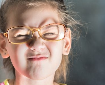 Beautiful child with glasses squinting from the light(Tagwaran)s