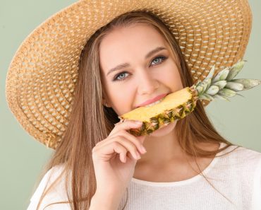 Beautiful,Young,Woman,Eating,Pineapple,On,Color,Background