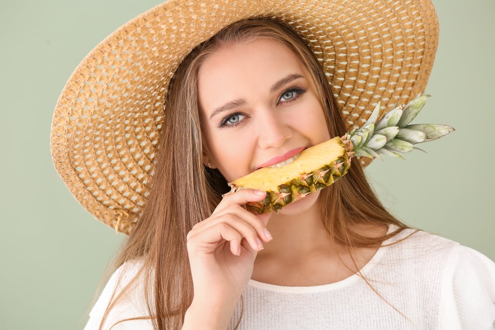 Beautiful,Young,Woman,Eating,Pineapple,On,Color,Background