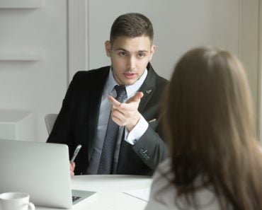 two-business-people-talking-at-the-office-desk-P3X36WH