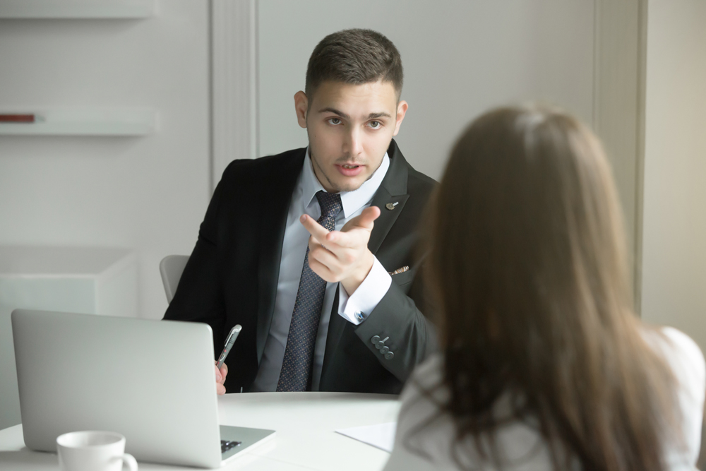 two-business-people-talking-at-the-office-desk-P3X36WH