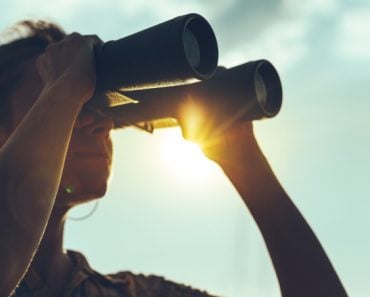 Beautiful,Young,Woman,Looking,Through,Binoculars,At,The,Sea,On