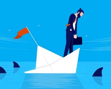 Businessman,In,Danger,-,Man,On,Sinking,Ship,With,Sharks