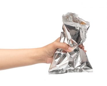 Hand,Holding,Plastic,Bag,Snack,Packaging,Isolated,On,White,Background