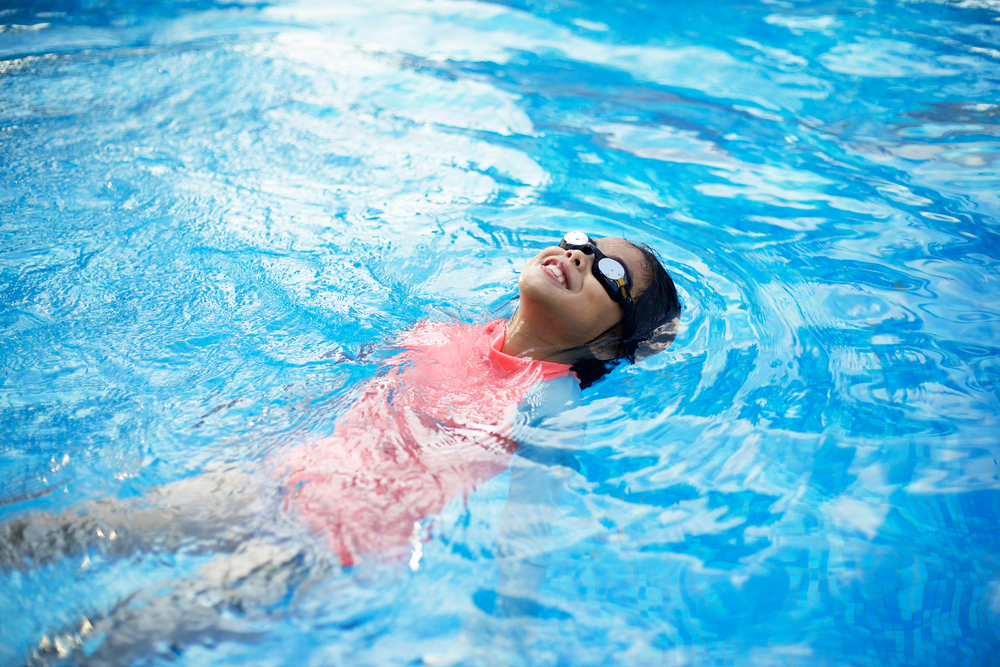 Young,Asian,Child,With,Peach,Swimwear,Floating,In,Pool.swimming,Lesson.