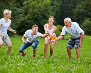 Happy,Man,Catching,Frisbee,While,Playing,In,The,Park