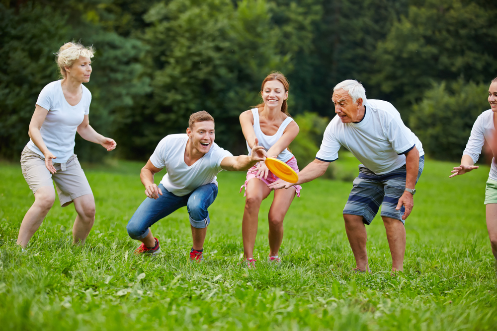 Happy,Man,Catching,Frisbee,While,Playing,In,The,Park