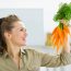 Happy,Young,Housewife,Holding,Carrots,In,Kitchen