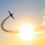 Silhouette,Of,An,Airplane,Performing,Acrobatic,Flight,At,Sundown.,Trace