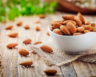 Almonds,In,White,Porcelain,Bowl,On,Wooden,Table.,Almond,Concept