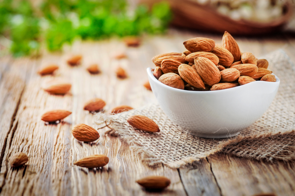 Almonds,In,White,Porcelain,Bowl,On,Wooden,Table.,Almond,Concept