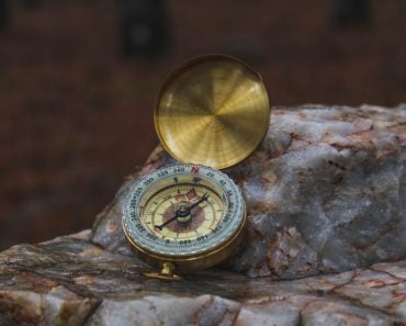 Detailed,Photo,Of,Vintage,Compass,On,Rock,In,A,Forest.