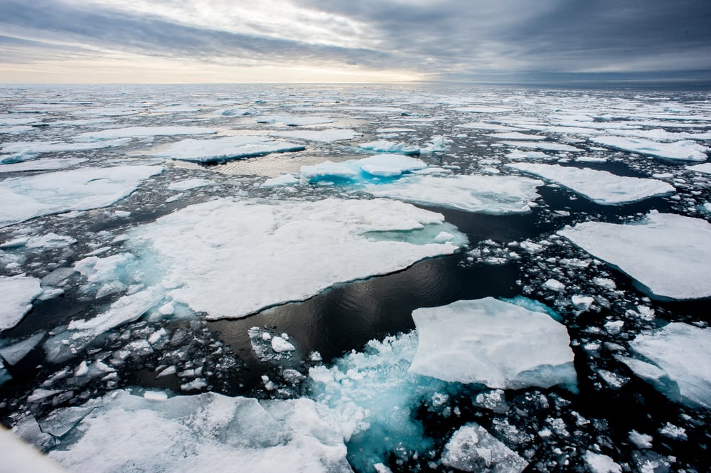 Dramatic wide angle view of melting arctic sea ice floes breaking up taken at sea
