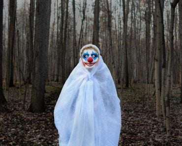 Evil,Clown,In,A,Mask,Standing,In,A,Dark,Forest