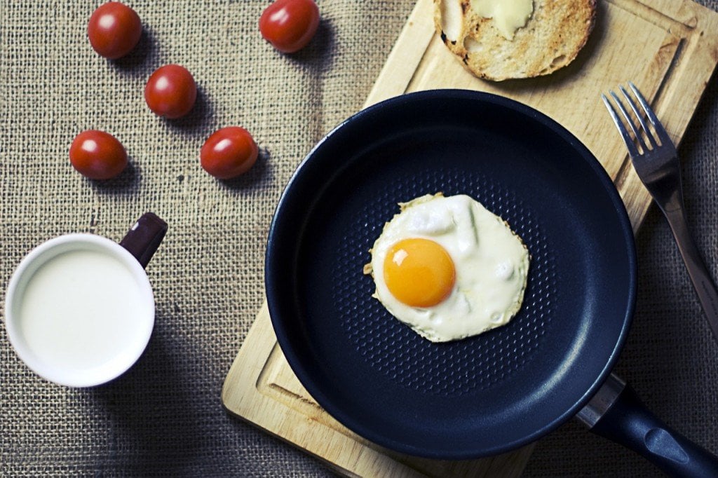 Frying egg in teflon cookware pan breakfast morning