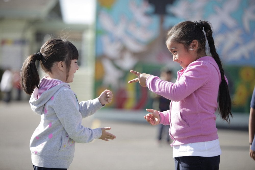 Two little girls playing Rock paper scissor playing children