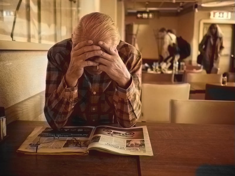 Exhausted old man reading book