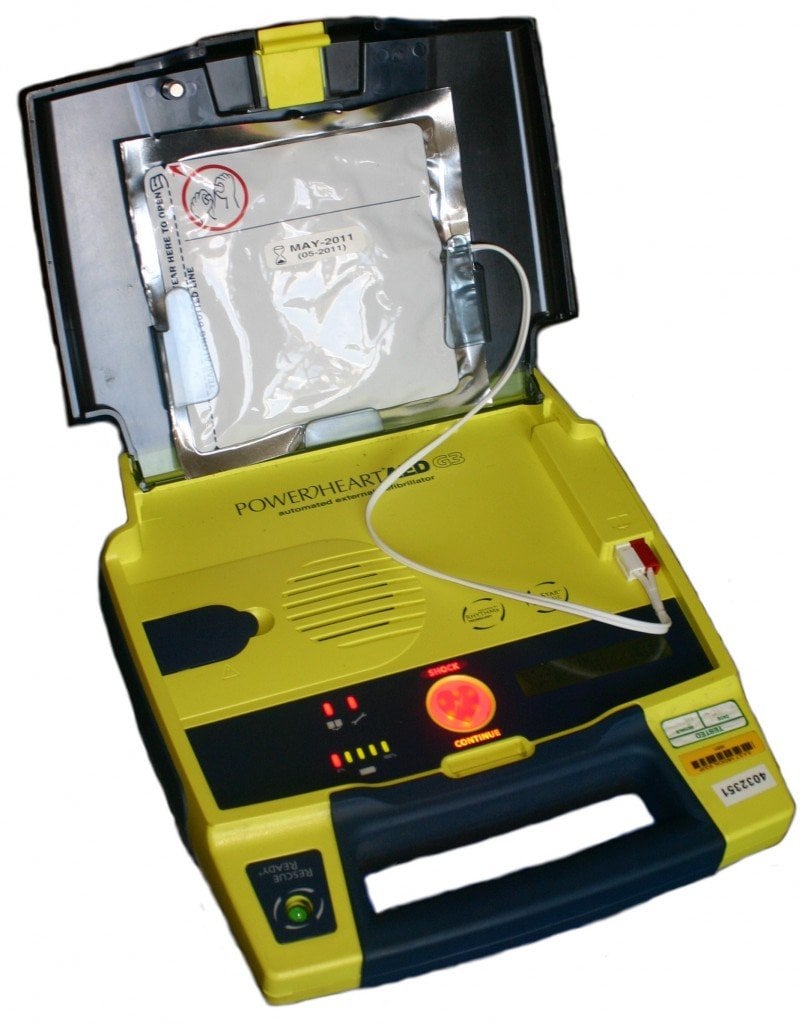 An automated external defibrillator ready for use. Pads are pre-connected. This model is a semi-automatic due to the presence of a shock button.