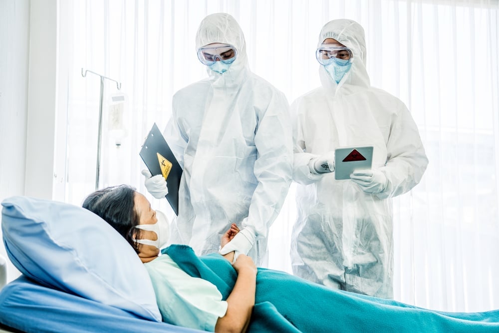 Doctors in the protective suits and masks are examining the infected aging female patient in the control area(Kobkit Chamchod)s