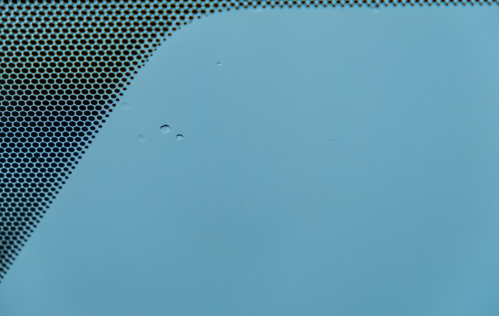 Black dots and bluish plain background with the few rain droplets on the car's glass after raining(SUKJAI PHOTO)s