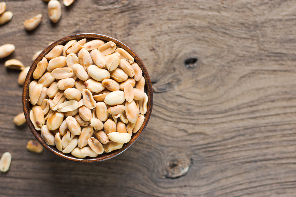 Roasted peanuts, salt, put in a cup. Brown was placed on the wooden floor. - Image(kram9)s