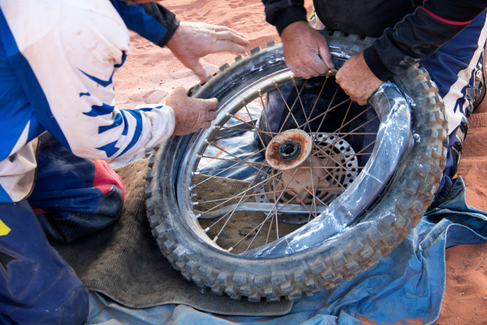 Fix motorbike tyre puncture in the desert, helping hands. - Image( Wendy Eriksson)s
