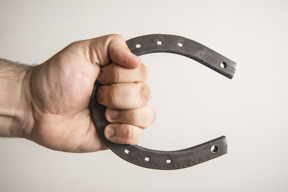 metal new Horseshoe on man hand isolated on white or gray background Idea of hard material and talisman for good luck - Image( maradon 333)S