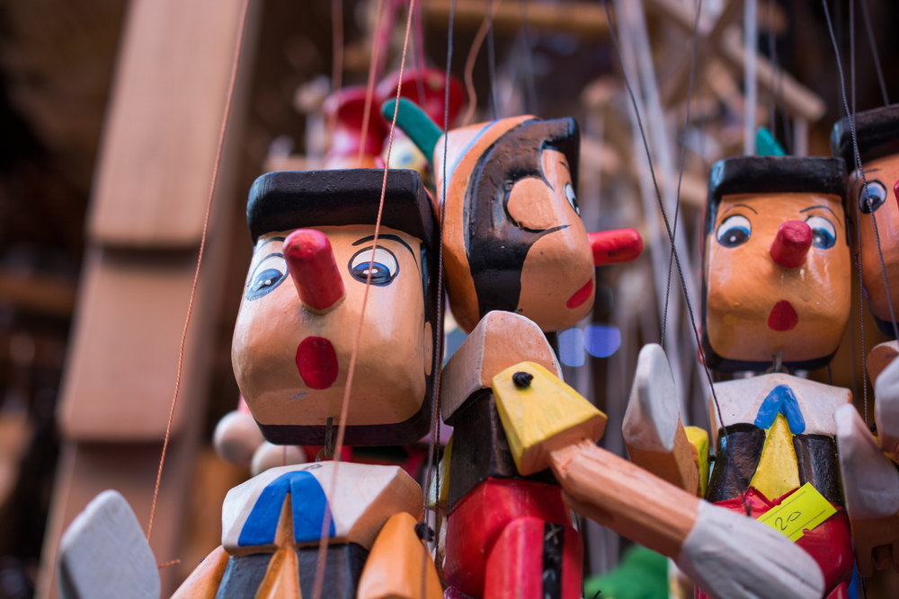 Set of wooden pinocchio dolls with his long nose on a white background - Image(Berke)s