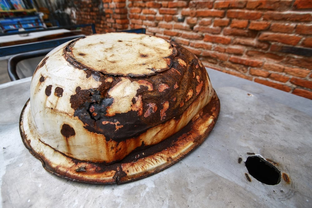 The pot is rust on the stainless steel plate next to the brick wall - Image(AOME1812)s