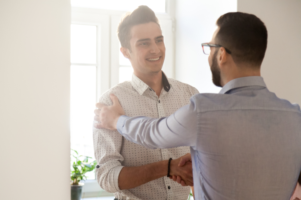 Empregado de aperto de mão grato do chefe que felicita com promoção de trabalho, apreciando bons resultados (fizkes) s