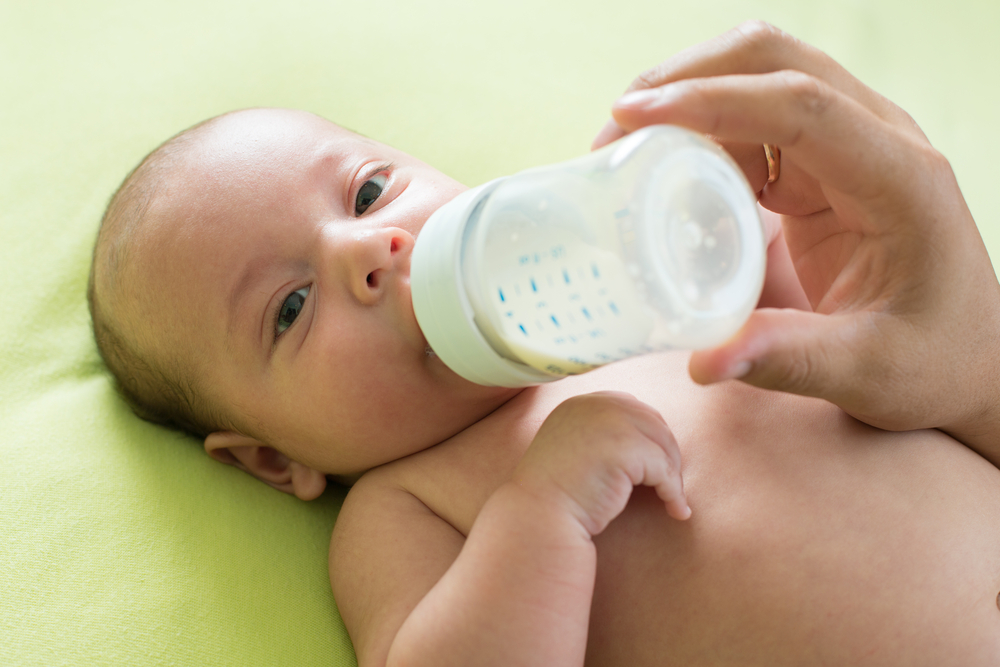 Mother or father feeds the baby with bottle - Image( Oksana Kuzmina)s