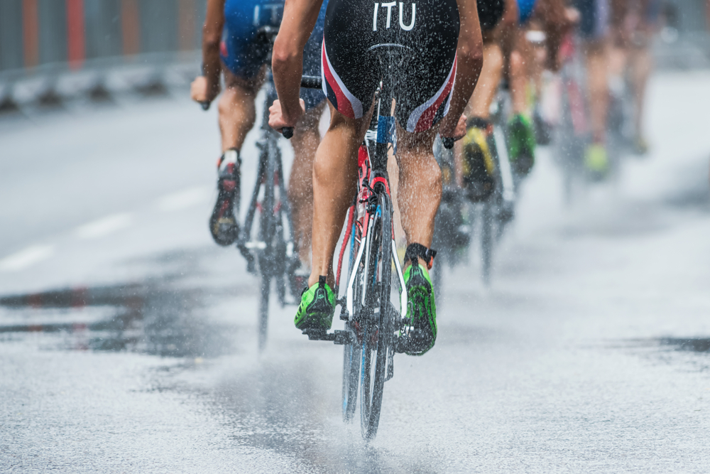 ESTOCOLMO - 23 DE AGOSTO Triatletas andando de bicicleta na chuva forte com água pulverizada da roda (Stefan Holm) s