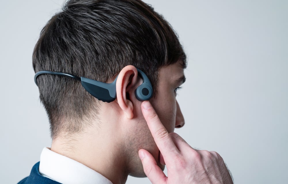 Young man wearing a bone conduction headphones(metamorworks)S