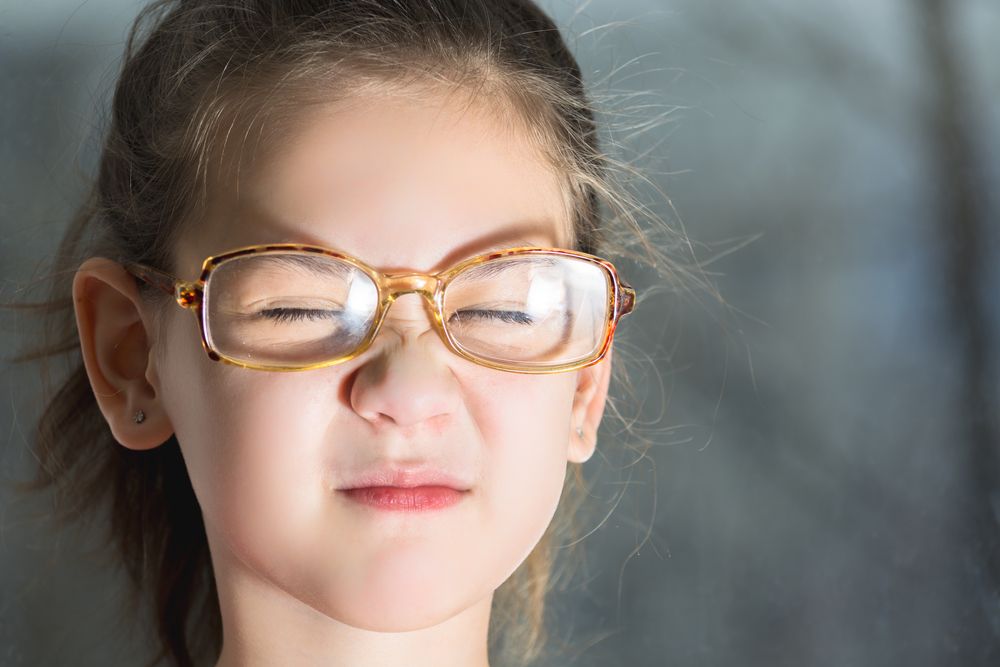 Beautiful child with glasses squinting from the light(Tagwaran)s