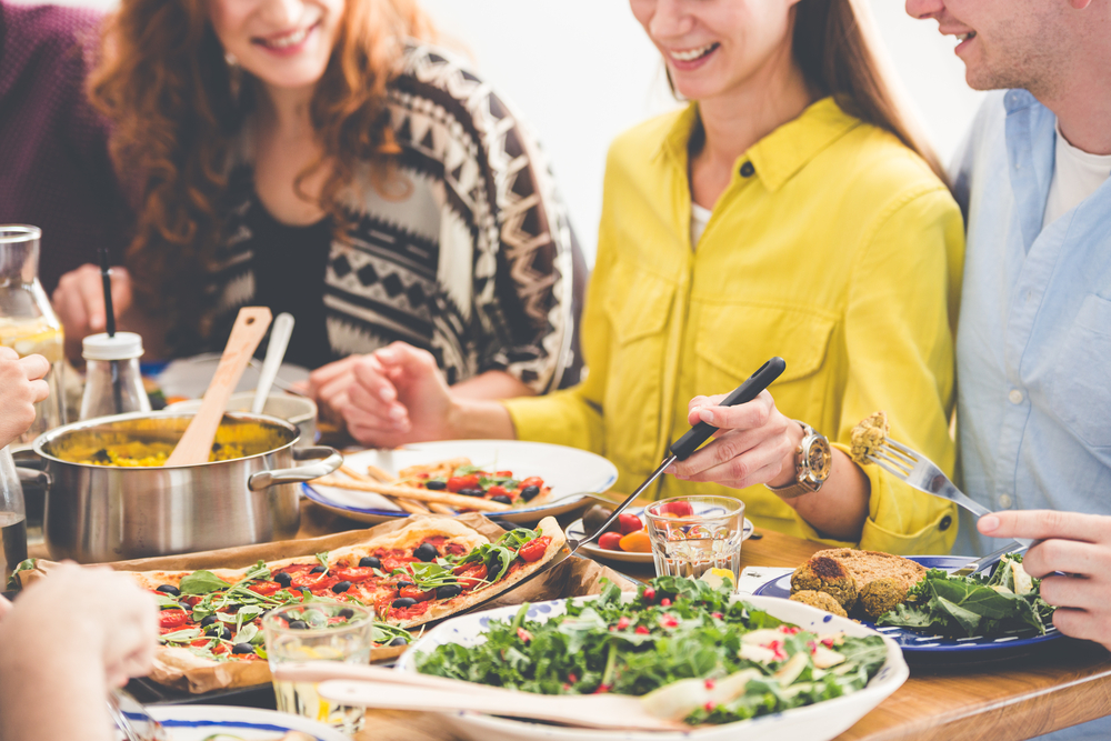 Vegetarianos comem alimentos saudáveis ​​e orgânicos durante reunião na casa de um amigo (Photographee.eu) s
