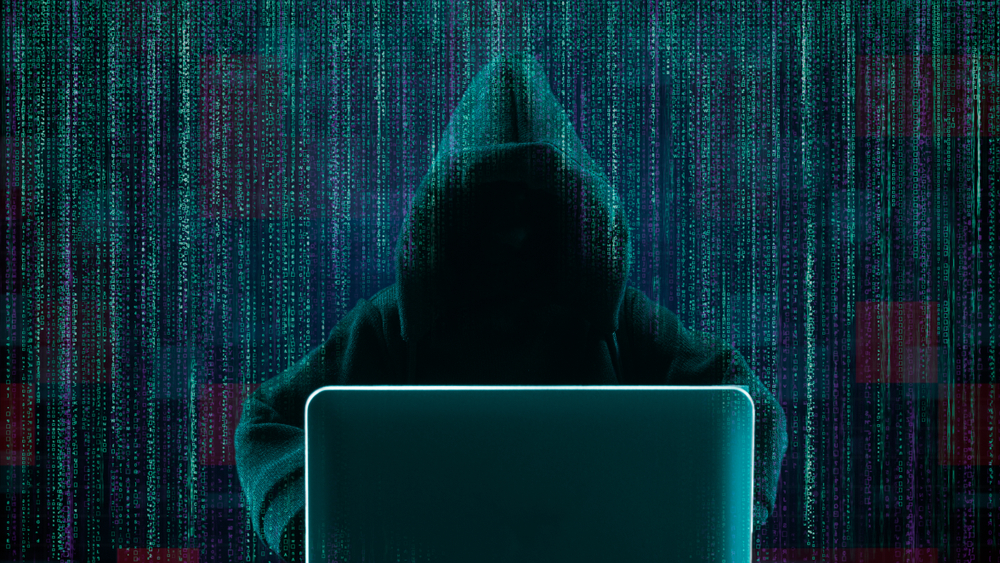 Hacker using laptop with abstract skull shape binary code(non c)s