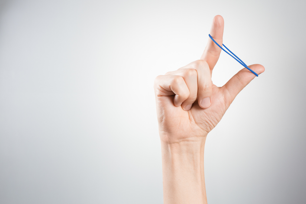 Hand playing with elastic hair band(Yeti studio)s