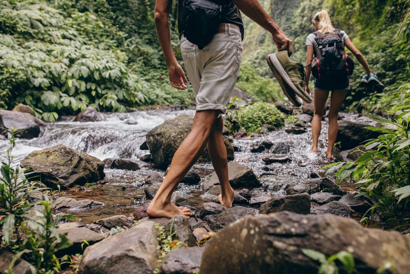 Low section shot of man and woman crossing the stream barefooted(Jacob Lund)s