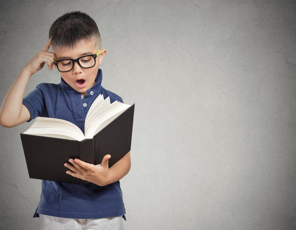 closeup portrait child with glasses reading book(pathdoc)s