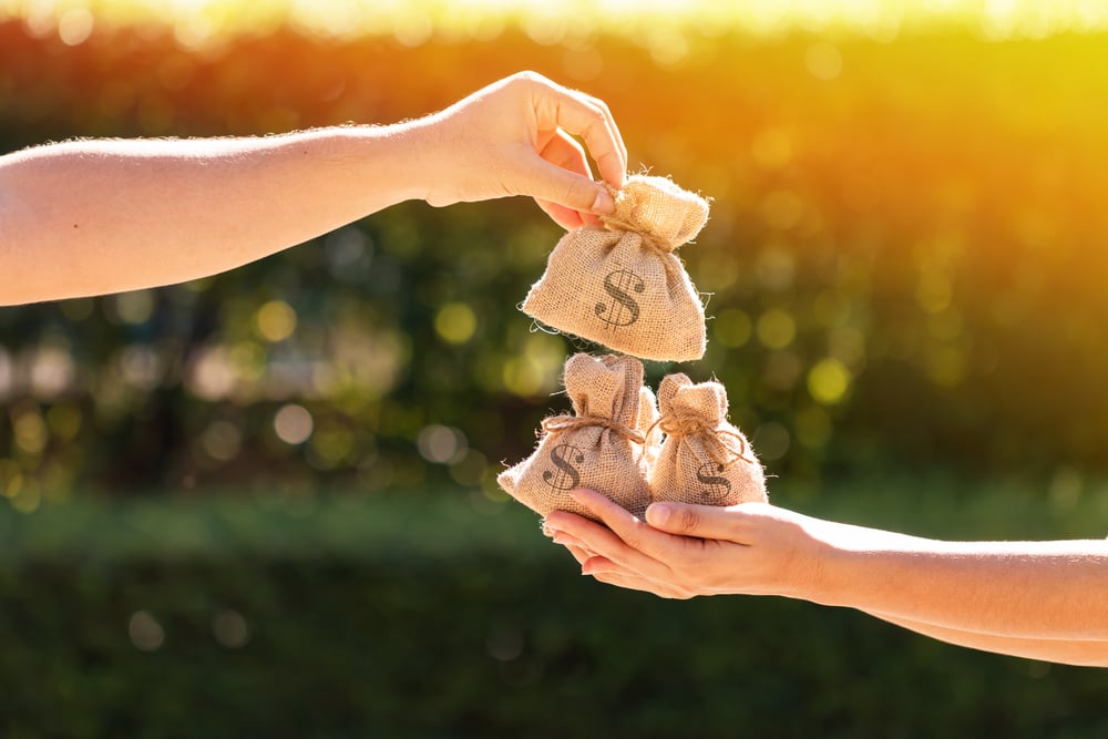 A man and a women hands hold a money bags in the public park for loans(Watchara Ritjan)S