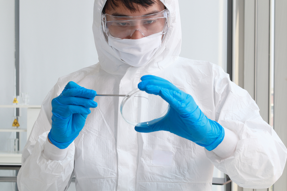 O pesquisador ou cientista médico em traje de EPI está esfregando o tecido (MAMIAE T8) s