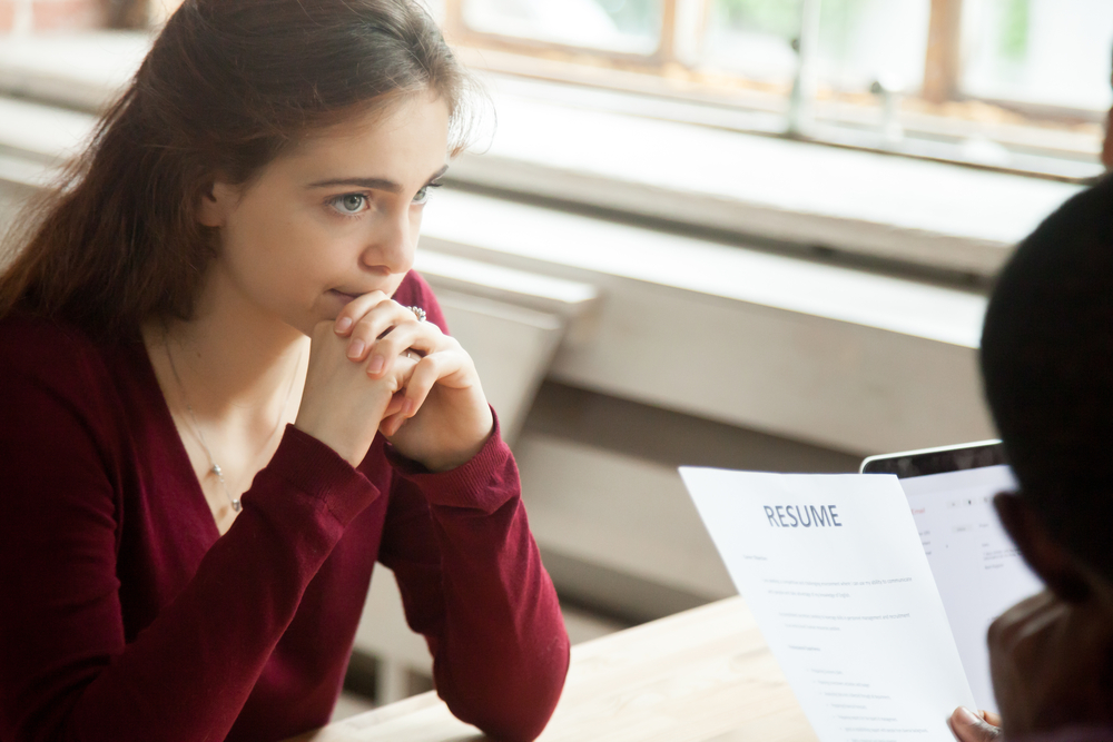 insecure woman candidate feeling worried while hr managers read discuss her cv resume(fizkes)s