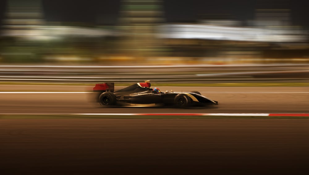 Corrida de carros de Fórmula 2.0 em alta velocidade com desfoque de movimento no fundo da cidade no escuro (Kuznetsov Alexey) s