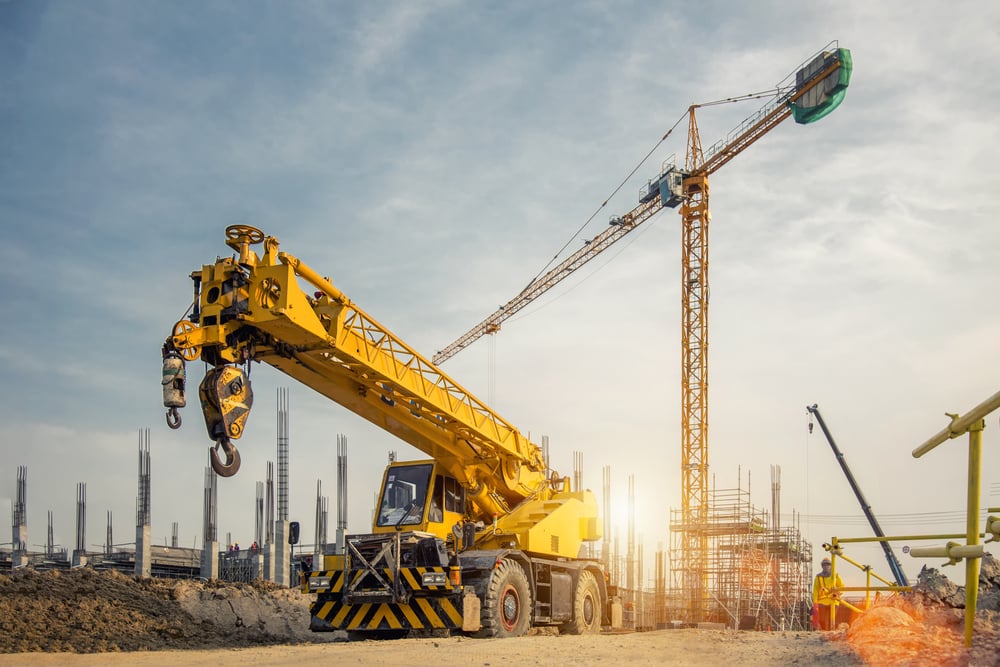 Guindaste móvel em uma estrada e guindaste de torre em canteiro de obras (Bannafarsai_Stock) s