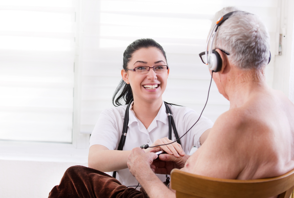 Smiling young nurse taking care about senior man with headset(Budimir Jevtic)s
