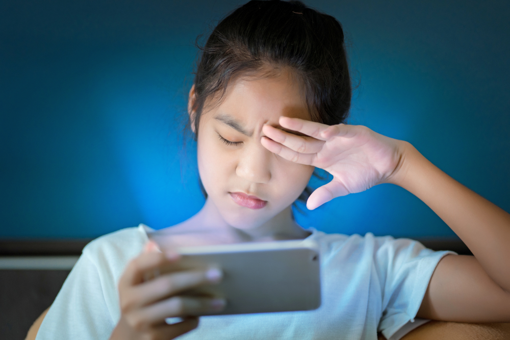 adolescente machucou os olhos porque ela tocou o telefone inteligente na luz escura e na luz azul (OHishiapply) s