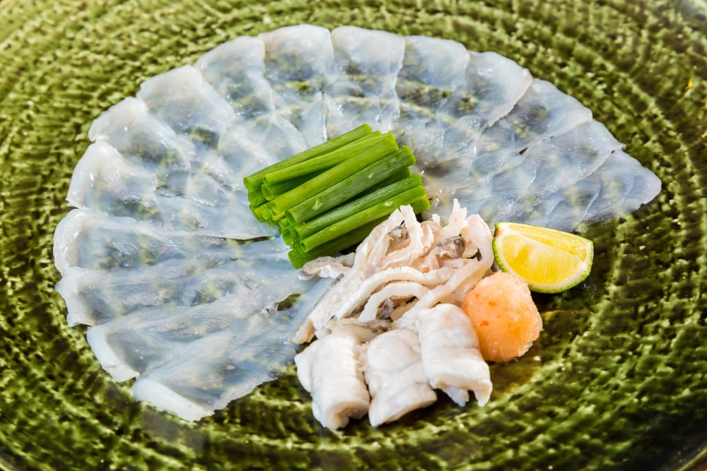 Fugu sashimi e as entranhas do fugu estão na placa verde (TheNUshutter) s