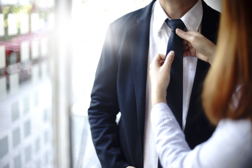 businessman prepare to go to present the project and the assitant help to adjust necktie(sabthai)s