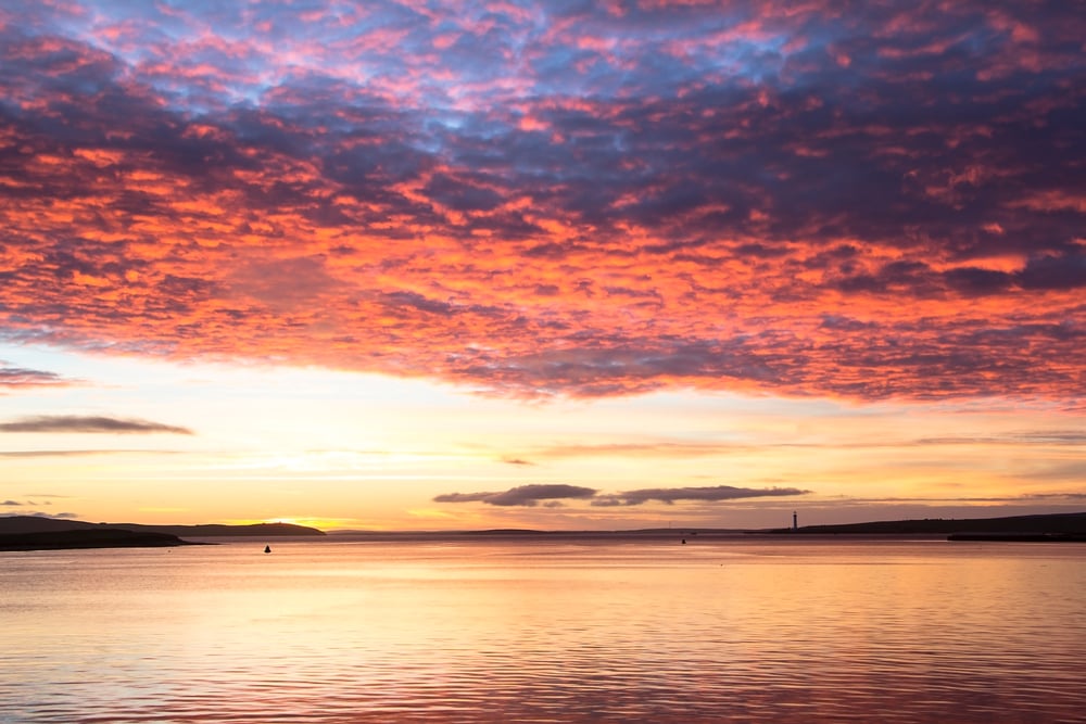 Nuvens multicoloridas acima do calmo mar do Norte na cidade de Orkney durante o nascer do sol (Maciej Orlicki) s