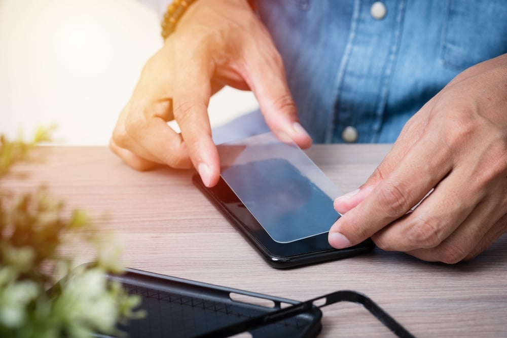 The man replacing the broken tempered glass screen protector for smartphone( Nor Gal)s